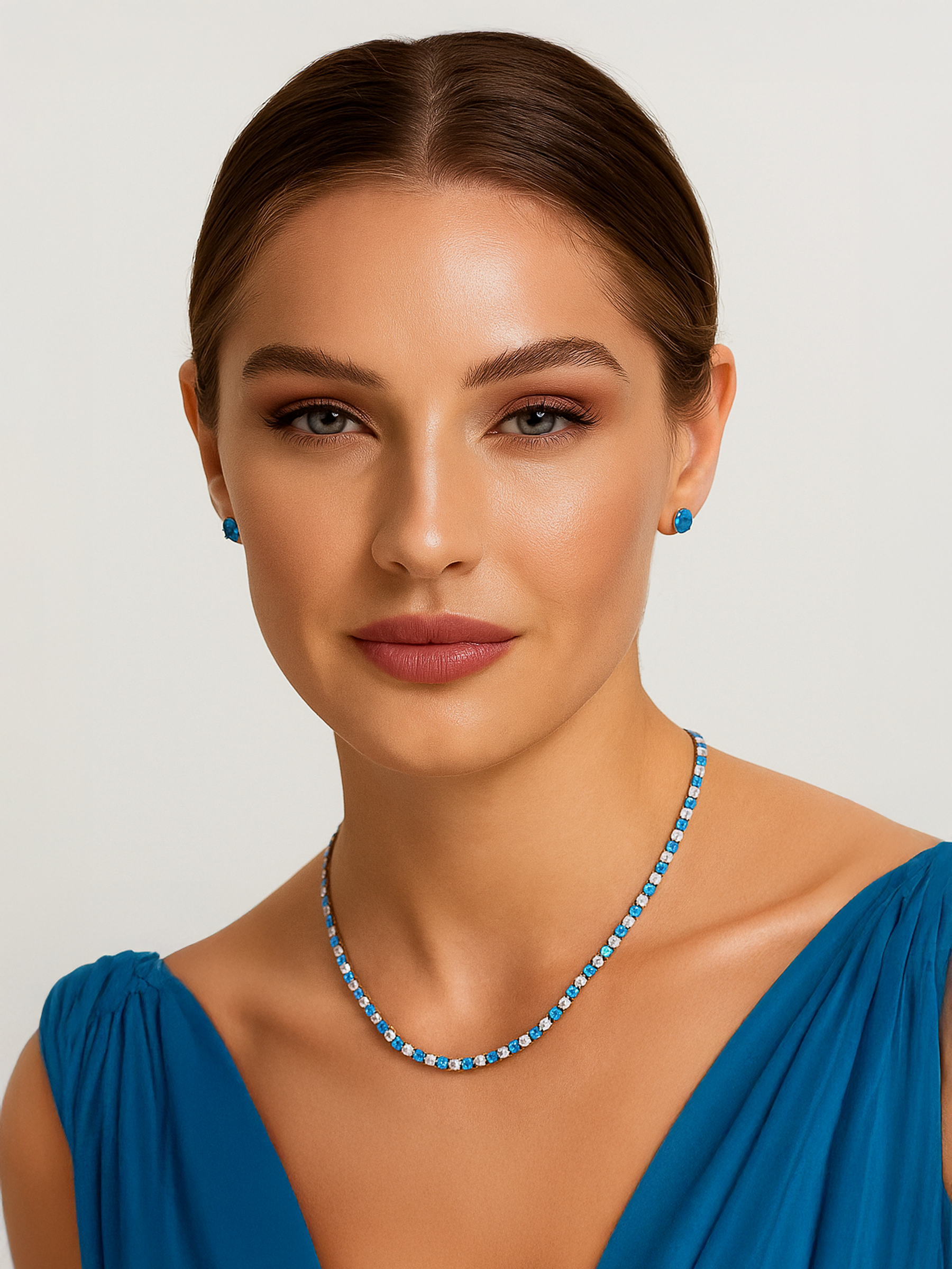 Woman wearing a blue and white Tennis necklace and earrings