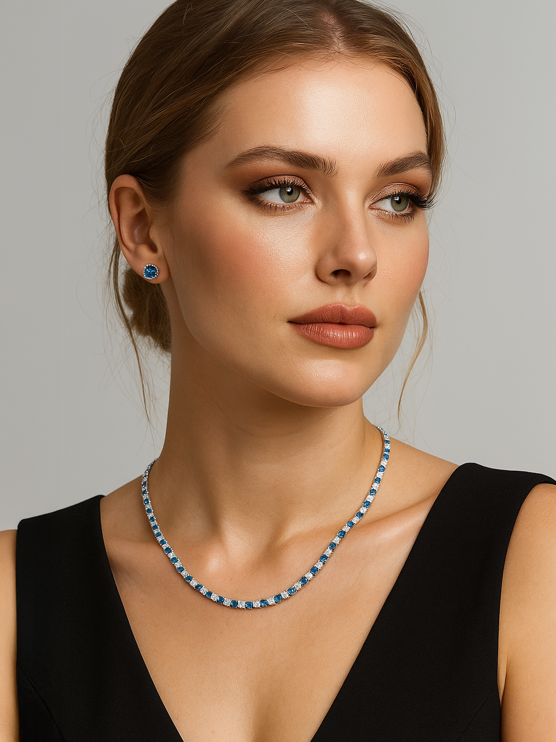 Woman wearing a blue and white Tennis necklace and earrings