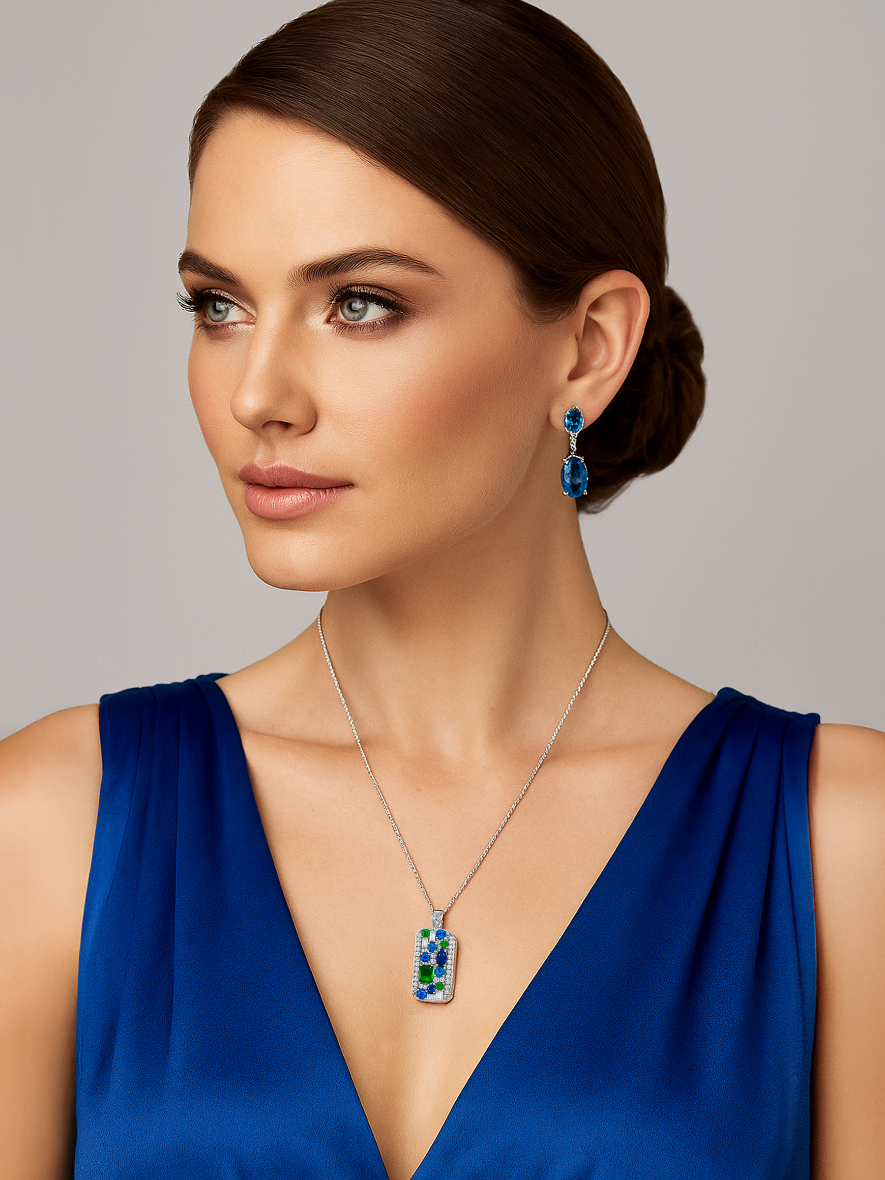 Woman wearing a blue dress with emerald and sapphire necklace